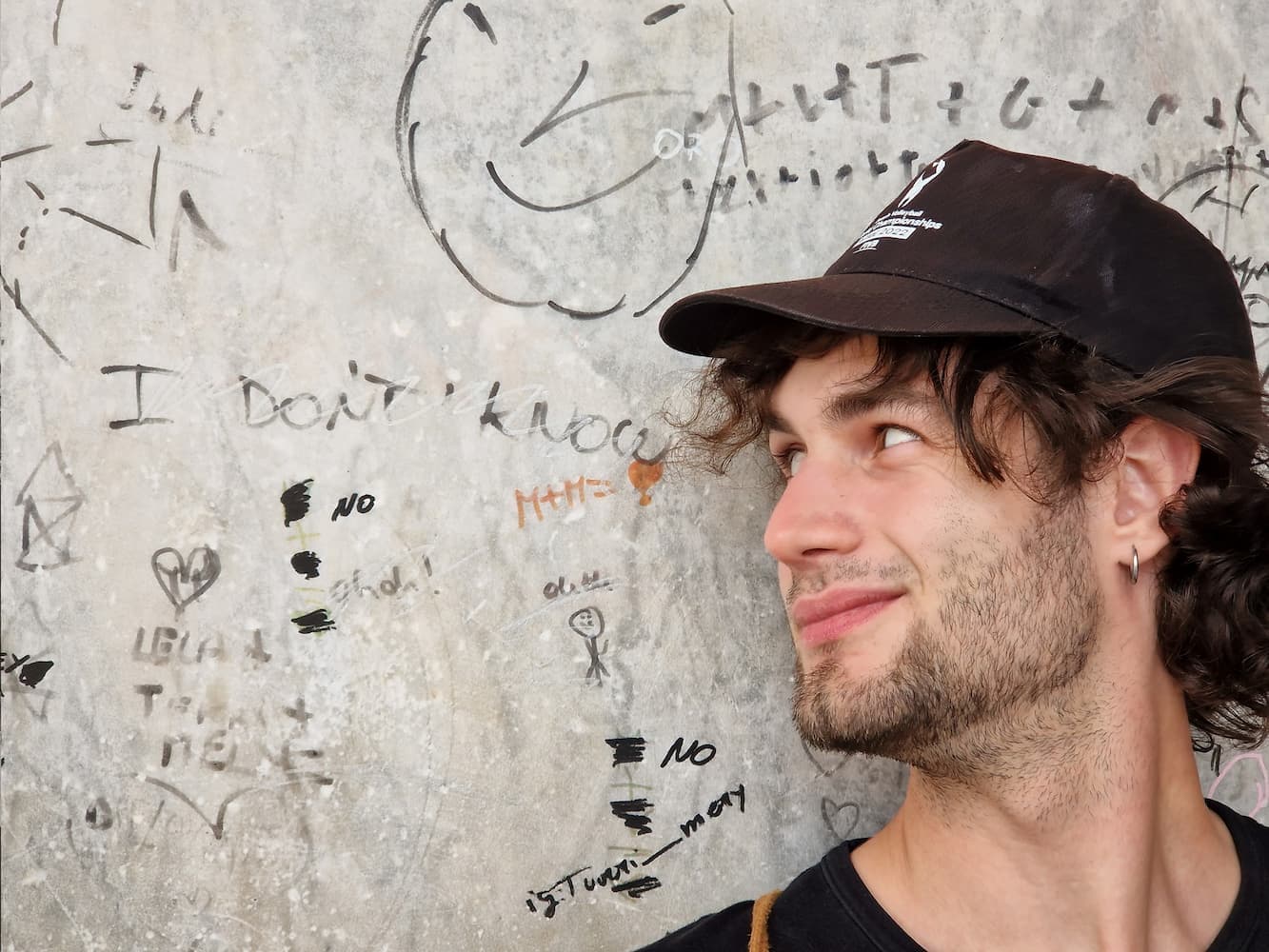 Riccardo Carretta beside a wall reading “I don’t know”